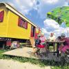Campen mit Komfort: Familie Kuhk sitzt vor einem Zirkuswagen auf dem Campingplatz Hofgut Hopfenburg bei Münsingen.