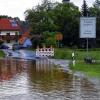 (ki)   „Land unter“ hieß es in Prölsdorf, einem Gemeindeteil in der Gemeinde Rauhenebrach, nachdem es am vergangenen Sonntag ununterbrochen geregnet und geschüttet hatte. Die nicht enden wollende Regenmenge  betrug fast 50 Liter pro Quadratmeter und ließ die Rauhe Ebrach von Theinheim Bach abwärts bis Prölsdorf über die Ufer treten. Die gewaltigen Wassermassen überfluteten nicht nur die Felder und Wiesen entlang der Rauhen Ebrach, sondern auch die Staatsstraße am Ortseingang von Prölsdorf sowie den Sportplatz des SC Prölsdorf, der erst vor Kurzem frisch vertikuliert wurde. Die Schäden, die das Hochwasser dementsprechend angerichtet hat, sind bis jetzt noch nicht genau feststellbar, dürften sich aber auf mehrere tausend Euro belaufen. Auch die Zufahrt zum Sportheim und zum gesamten Sportgelände war völlig überflutet