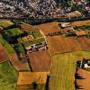 Archäologische Aufklärung aus der Luft: Der Blick aus der Vogelperspektive auf den Kappelberg lässt auf dem Feld im Vordergrund unterhalb der kleinen Gertraudiskapelle (links) die sich auf dem Feld abzeichnenden Umrisse des mächtigen Grabens der einst imposanten Befestigungsanlage erkennen. Zu Füßen des Kappelbergs lag im Tal – grob begrenzt durch den heutigen Aussiedlerhof/Hofladen Braun, den Lindelachshof und die Klesenmühle – das nach 1631 durch die Schweden zerstörte Dorf Lindelach.