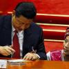 Chinas neuer starker Mann: Präsident Xi Jinping gibt der Vertreterin einer ethnischen Minderheit während der Sitzung des Volkskongresses in Peking ein Autogramm.