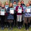 (zis)   Die Reitkinder des Reiterhofes Bartel in Feuerbach haben in den Osterferien an einem Lehrgang zur Vorbereitung auf das Kleine und Große Hufeisen teilgenommen. Der Lohn für die Mühen: alle zwölf haben die FN-Prüfung bestanden. Egal, ob Kleines (kH) oder Großes Hufeisen (gH), die Prüflinge des Reiterhofs Bartel waren vor ihren Prüfungen allesamt tierisch nervös, wie es im Presseschreiben heißt. Mit zittrigen Händen legten sie nach dem Satteln letzte Hand an und verpassten ihren Pferden Valoroso, Astonia, Lennox, Mythos und Rebell geflochtene Mähnen, bürsteten und zöpften die buschigen Ponymähnen von Tiffi, Flitzi, Picco, Dancer, Hermine, Tali, und dem kuscheligen Tom, bis es endlich losging mit Theorie und Praxis. Im praktischen Teil mussten die Kids für das Große Hufeisen unter anderem einen kleinen Parcours springen. Am Ende haben alle zwölf Mädchen bestanden. Im Bild die Prüflinge mit Urkunden und Abzeichennadeln (von links): Sara Conradi (gH), Lilly Köhler (gH), Alicia Helbich (gH), Alina Brügel (kH), Lara Feth (kH), Tanja Eyßelein (kH), Milena Winter (gH), Jennifer Weiss (kH), Emilie Rehberger (kH), Julie Büttner (kH), Nele Moßmann (kH) und Lisa Strasser (gH).