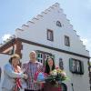 Begrüßungsgeschenke für die neuen Pächter der „Weißen Mühle“: Bürgermeisterin Rosi Schraud (links) überreichte Norbert Schweizer zwei Gemeindechroniken und seiner Frau Anette einen Blumenstrauß.
