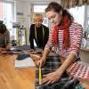 Das wird ein Geschenk: Florian Kurz nimmt im Nähcafé Edeltraud Maß für einen Brotbeutel. Schneiderin Sarah Mittermeier ihre Gäste beim Arbeiten am Schneidetisch und an der Nähmaschine.