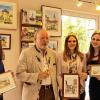 Gerhard Weihrauch zeigt im Winzerkeller Randersacker Bilder von 40 fränkischen Rathäusern. Die Weinprinzessinnen Klara, aus Randersacker, Lisa aus Sommerhausen und Maria aus Theilheim (von links) assistierten bei der Ausstellungseröffnung.