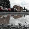 Immer wieder aufs Neue ist es für die Frau ein Ärgernis, wenn sie auf dem Parkplatz in der Hofheimer Bahnhofstraße, zwischen den Bahngleisen und dem Lagerhaus, ihr Auto abstellt, denn dann beginnt das „Wassertreten“. Sie ärgert sich: „Sollen wir extra Schuhwerk fürs Laufen über den Parkplatz anziehen?“, fragt die Verkäuferin. Besonders nach den Regenfällen der vergangenen Tage ist der öffentliche Parkplatz auf dem geschotterten Gelände wieder übersät mit Schlaglöchern voller Wasser.   Eine Hofheimerin, die dort gerade ihr Fahrzeug abgestellt hat, nimmt's einigermaßen mit Humor: „Das ist der Parkplatz 'Seen-Land'.“ Und fügt hinzu: „Als es die ganze Zeit gefroren hatte, da ging's ja noch“. Aber nachdem es nun getaut und geregnet hat, macht der Parkplatz dem Namen „Seen-Land“ alle Ehre (wenngleich die Perspektive des Bildes ein wenig übertreibt). Abhilfe soll kommen, erklärt auf Anfrage der Redaktion, Hofheims Bürgermeister Wolfgang Borst. Die Löcher werden mit Schotter aufgefüllt. Allerdings hätten die Mitarbeiter des Bauhofs derzeit alle Hände voll mit den vielen Rohrbrüchen im Stadtgebiet zu tun. Foto: Alois Wohlfahrt
