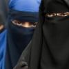 Verschleierte Frauen schauen durch die Schlitze ihrer Nikab. Foto: Boris Roessler/Archiv