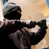 Ein als Einbrecher verkleideter Mann hebelt in der Kriminalpolizeilichen Beratungsstelle der Polizei in Hamburg ein Fenster auf.