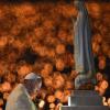 Papst Franziskus betet vor dem Heiligtum von Fátima. Im Hintergrund leuchten die Kerzen Tausender Gläubiger.