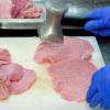 Mit dem Fleischklopfer werden die Fleischstücke für die Cordon Bleu in Form gebracht. Es muss schnell gehen, an der Panierstraße herrscht hohes Tempo.