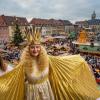 Pünktlich um 14.30 Uhr stieg das Christkind (Rebecca Ammon) mit goldenen Locken, goldenem Umhang und goldener Krone – begleitet von zwei Engeln – die große Freitreppe zur Rathausdiele hinauf. Dort warteten schon gespannt Kindergartenkinder, die dem Christkind ein paar Fragen stellten und drei Lieder vorsingen durften. Die Kinder durften sogar kurz mal die Flügel des Christkinds anfassen. Ganz vorsichtig, fast ehrfürchtig gingen die Knirpse zu Werke. An Bürgermeisterin Sorya Lippert war es schließlich, das Christkind seitens der Stadt Schweinfurt offiziell willkommen zu heißen, bevor es auf dem Balkon des Rathauses seinen berühmten Prolog sprach. Der Weihnachtsmarkt war jedenfalls sehr gut gefüllt. Anschließend kutschierte das Christkind mit seinen Engeln in einer Pferdekutsche zum Markt, wo es auf der Bühne Schokolade an die vielen wartenden Kinder verteilte. Einige von ihnen hatten dem Nürnberger Christkind sogar ein Bild mitgebracht.