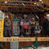 „Leise rieselt der Schnee“ sang der Schweinfurter Kinderchor unter Leitung von Paul Göttinger geschützt unterm Bühnendach, doch für die Besucher der Stollenwiegenaktion der Bäckerinnung auf dem Weihnachtsmarkt konnte von leisem Schnee-Riesel keine Rede sein. Dicke Flocken schickte Frau Holle Sonntagnachmittag aus dem Himmel. Doch die durchaus zahlreichen Besucher ließen sich nicht abschrecken, hatten ihre Freude am von Edgar Bernhardt launig moderierten Stollenwiegen für einen guten Zweck.  Man hatte schon bayerische Minister, den Schweinfurter OB, die Landtagspräsidentin, einen Krimi-Autor und Kabarettisten auf der Waage, aber nie einen Sportler. Gekommen war Gerd Klaus, Trainer und Sportdirektor des Fußball-Regionalligisten FC 05 Schweinfurt. Der war früher Fußball-Profi, was man ihm heute noch ansieht. Deshalb brachte er auch seine Töchter Charlotte und Gina-Marie mit und zusammen brachte das Klaus-Trio beachtliche 128 Kilogramm Stollen auf die Waage. „Eine tolle Aktion, gerade für die Bedürftigen“, freute sich Gerd Klaus, der gerne gekommen war und auch das erhoffte Stück Stollen bekam, als der meterlange Stollen auf dem Tisch vor der Bühne für die Besucher angeschnitten wurde.  Die 128 Kilo Stollen werden nun zu gleichen Teilen von Innungsobermeister Gerhard Götz an die Tafel in Haßfurt, an Schweinfurter Seniorenheime und bei der Sozialweihnacht der Stadt ausgegeben. Ein Video finden Sie unter www.facebook.com/schweinfurter.tagblatt.