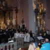 (Besinnlich ging es beim Weihnachtskonzert in der Ostheimer St. Nikolaus-Kirche zu. Nur der Altarraum war hell erleuchtet. Im Kirchenschiff sorgten Kerzen für eine heimelige Atmosphäre. Die Blaskapelle Ostheim, der Chor Chrisma und die Kinder der Flötengruppe trugen weihnachtliche Lieder vor. Darunter zum Beispiel „Little Drummer Boy“, „Jingle Bells“ oder „Machet die Tore“ weit. Zwischen den Liedern gab es für die Besucher einige Gedanken zur Adventszeit zu hören.   „Wenn die stille Zeit vorbei ist, dann wird es auch wieder ruhiger“ – führte etwa Sprecherin Susanne Schwinn ein Zitat des Münchner Humoristen Karl Valentin an. In den Worten Valentins liege eine traurige Wahrheit, gab sie zu bedenken. Statt in der Vorweihnachtszeit Ruhe und Gemeinsamkeit zu suchen, „hetzen wir oft von Termin zu Termin.“ Die Besucher waren daher eingeladen während des Konzerts in der Kirche gemeinsam ein wenig zur Ruhe zu kommen und die Zeit zu genießen. Anschließend bot sich vor der Kirche bei Glühwein und Bratwürsten die Möglichkeit zum geselligen Beisammensein.