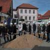 Mit dem Spatenstich gaben die Vertreter der beteiligten Behörden und Firmen den offiziellen Startschutz zum Neubau des Bürgerhofes im Ortskern von Erlabrunn. Die ehemalige Scheune aus dem 16. Jahrhundert am linken Bildrand soll dabei zur Kulturscheune umfunktioniert werden. In der Bildmitte im Hintergrund das bestehende Rathaus, von wo die Verwaltung nach Fertigstellung in den Bürgerhof umzieht.