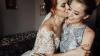 Beautiful bride and bridesmaid posing in room before wedding