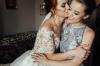 Beautiful bride and bridesmaid posing in room before wedding