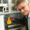 SKZ-Bereichsleiter Georg Schwalme holt aus der „Brennkammer” eines 3D-Druckers einen Gegenstand aus Kunststoff. Das Institut forscht zusammen mit der Industrie und Hochschulen.Fotos: Jürgen Haug-Peichl