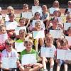 Stolz präsentieren die sportlichen Schülerinnen und Schüler der Grundschule ihre Ehrenurkunden.