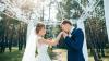 The groom kisses the bride's hand at the wedding ceremony. The bride and groom in wedding dresses on natural background. Wedding day. The bride and groom are walking through the forest.