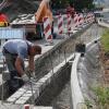 Mitarbeiter des Städtischen Bauhofs errichten im Auslauf der Mühlbacher Brücke in Bad Neustadt eine Querungshilfe für Badegäste, die die Kreisstraße vom Parkplatz „Am Zent” in Richtung Triamare überqueren wollen.
