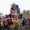 Gruppenbild der Schüler auf und an der Kletterpyramide mit Bürgermeister Alfred Frank, Pater Marek Sobkowiak und Schulleiterin Anja Kaufmann in der Mitte auf den Seilen.
