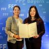 Judith Gerlach, Staatsministerin für Digitales, (links)  überreichte die Urkunde der Programmprämie für ein herausragendes Filmprogramm bayerischer Filmtheater an Carolin Dunst, Burg-Lichtspiele Mühlbach.