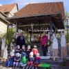 Walli Keller (hinten links) und Klara Kaiser (rechts) freuten sich über den Besuch der Krippenkinder des Riedener Kindergartens an ihrem geschmückten Stangenbrunnen.