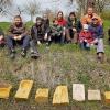 Der Obst- und Gartenbauverein Unfinden bearbeitete unter Anleitung des Königsberger Steinmetz Michael Tully heimischen Sandstein zu Insekten- und Vogel-Wasserstellen. Zu Beginn wurden die verschiedenen Sandsteine des Haßbergkreises und des Untermains vorgestellt und erläutert, wie sie sich bearbeiten lassen. Dabei zeigte sich, dass der Bucher Sandstein, der aus dem Gebiet um Ebern stammt, für das Bearbeiten mit Klüpfel und Meißel am geeignetsten ist. Eine „Steine-Klopferin“ entschied sich für den Ebelsbacher Sandstein, der sich durch seine besondere Farbe von den anderen abhob und zwei „Stein-Klopfer“ wagten sich an den roten, sehr harten Miltenberger Sandstein. Nach einer kurzen Einweisung in die Handhabung der Werkzeuge, ging es daran, die Vertiefung aus dem Sandstein herauszuarbeiten. Zuerst wurde mit Fäustel und Spitzeisen das Material grob weggeschlagen, danach mit Klüpfel und Zahneisen nachgearbeitet, um schließlich mit dem Beizeisen die Fläche wieder zu glätten. Sollte die Fläche noch glatter werden, konnte mit dem Korundstein die Oberfläche geschliffen werden. Damit die Kinder „schnell“ zu einem Ergebnis kamen, hatte Steinmetz Tully pneumatisches Werkzeug dabei. Die Erwachsenen durften ihre Wasserstellen mit Handwerkzeugen herstellen. Es wurden Herzen, Kuhlen, Sterne und Füße aus den Steinen herausgearbeitet. Besonders Eifrige verzierten ihre Kunstwerke noch mit einer Jahreszahl oder den eigenen Initialen. Die Verpflegung mit süßen und herzhaften Köstlichkeiten übernahm die Crew des OGV. Durch diese Aktion will der OGV einen Beitrag zum Erhalt der Insekten- und Vogelwelt leisten, was wiederum für den Obstanbau und das Bewirtschaften des eigenen Gartens essenziell wichtig sei, so der OGV. (sn)