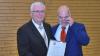 Gunther Ehrhardt (rechts) überreicht Josef Schäfer die Ehrenurkunde der Gemeinde zur Ernennung zum Altbürgermeister.
