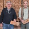 Seit Jahrhunderten werden in Zeilitzheim Ziegelsteine produziert. Kreisarchivpfleger Hilmar Spiegel (links) hat gemeinsam mit Lorenz Englert, Senior-Chef des Zeilitzheimer Ziegelwerks die Historie des traditionsreichen Baumaterials erforscht. Spiegel hält den ältesten, über 200 Jahre alten, in Zeilitzheim hergestellten Ziegel, einen so genannten Handschlagziegel in Händen. Lorenz Englert zeigt ein Exemplar (Dreilochziegel) aus den Anfängen der Produktion seines Vaters um 1950. Im Hintergrund sind die Mauerziegelsteine zu sehen, wie sie aktuell im Ziegelwerk in Zeilitzheim computergesteuert hergestellt werden.