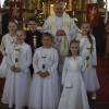 Das Bild zeigt die Kommunionkinder mit dem Pfarrvikar vor dem Altar (vorne von links): Vreni Ring, Elina Kram und Theresa Bäuerlein; (Mitte von links): Collien Hauck, Paul Vetter und Elena Pfrang. Hinten Pfarrvikar Zbigniew Jan Gulbicki.