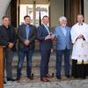 Schlüsselübergabe vor historischem Hintergrund. Architekt Thomas Schmucker, Historiker Georg Menig, Bürgermeister Peter Juks, Altbürgermeister und Archivar Peter Wesselowsky, Pfarrer Jochen Ley und Pfarrer Klaus Weber aus Hopferstadt.