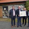 Vor 100 Jahren kam der Strom nach Oberweißenbrunn, Frankenheim und Haselbach und damit auch an den Kreuzberg. Zur Erinnerung gab es für Bürgermeister Georg Seiffert die Kopien der Originalverträge. Die Übergabe fand vor der künstlerisch gestalteten Trafostation am Kreuzberg statt. Das Bild zeigt von links: den neuen Geschäftsführer der Klosterbetriebe GmbH Christian Weghofer, Bürgermeister Georg Seiffert, Christine Pfaff und Bernd Göttlicher.