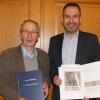 Feierlich überreichte Bürgermeister Holger Baunacher (rechts) dem Wonfurter Heimatforscher Raimund Vogt seine Aufzeichnungen als repräsentatives Buch.