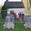 Einige Gernacherinnen und Gernacher verfolgen gespannt, wie die Glocken eine nach der anderen vom Kirchturm geholt werden - und halten diesen historischen Moment mit ihren Smartphones fest.