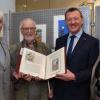 Radierungen und Aquarelle von Günter Jäger sind noch bis Ende des Monats in der Geschäftsstelle der Sparkasse in Ochsenfurt zu sehen. Ein handgeschriebenes Buch mit Originalradierungen von Ochsenfurter Ansichten hat der Künstler außerdem an Bürgermeister Peter Juks übergeben. Mit im Bild Stadtarchivar Peter Wesselowsky und Sparkassen-Geschäftsstellenleiterin Marion Frischholz.