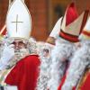 dpatopbilder - 02.12.2018, Baden-Württemberg, Friedrichshafen-Jettenhausen: Sechs Mitglieder der Nikolausgilde sitzen als Nikoläuse verkleidet während eines Gottesdienstes in der katholischen Kirche, von wo aus sie ausgesendet werden. Foto: Felix Kästle/dpa