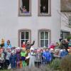 Das "Heer" vor dem Kleinrinderfelder Rathaus: Kindergartenleiterin Daniela Reuß (Bildmitte hinten) und ihr Team freuen sich mit den Kindern über den gelungenen Faschingsspaß. Von oben grüßen die tapferen „Verteidiger“ Waltraud Kiesel-Knobloch (links) und Julia Henneberger (rechts).