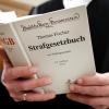 Ein Richter mit dem Strafgesetzbuch (StGB) in der Hand. (Symbolbild)