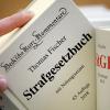 Ein Jurist nimmt das Strafgesetzbuch aus dem Regal. (Symbolfoto)