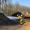 Mit einem Radlader wurde das Brandgut aus der Lagerhalle ins Freie gebracht und dort von Atemschutzträgern der Feuerwehren abgelöscht.