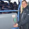 Busfahrerin Tanja Heckenlauer führt die Nutzung des Desinfektionsmittel-Spenders vor. Sie wurden im hinteren Einstieg der Linienbusse der Firma OVB Omnibusverkehr Bischofsheim angebracht.