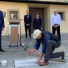 Bildhauer Thomas Reuter bei der Verlegung der Mosaikplatte "Versöhnung für Europa" vor der Kirche St. Stephan - im Hintergrund von links nach rechts Bürgermeister Martin Heilig, Stadtrat Lukas Weidinger, Elisabeth Peper von der Nagelkreuzinitiative, Stadtrat Willi Dürrnagel und Dekan Wenrich Slenczka.