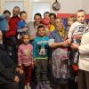 Frau Rösch (ganz links) beim Besuch einer Familie, die in einem Häuschen mit 3 kleinen Zimmern wohnt. Küche und WC sind im Freien.