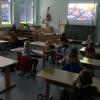 Die Klasse 2b verfolgt gespannt die erste digitale Monatsfeier in ihrem Klassenzimmer.