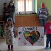 Kindergartenleiterin Leslie Reinhard (links) und einige Kindergartenkinder bedankten sich bei Maria Arnold (rechts) mit einem selbstgestalteten Poster.