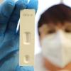 Eine medizinische Mitarbeiterin hält einen Antigen-Schnelltest in die Kamera. Das Testergebnis: negativ.