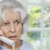 Worried Senior Woman Answering Telephone At Home, enkeltrick