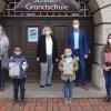 Patenschaftsbestätigung für das Präventionsprojekt "Klasse 2000" an der Schillerschule. Die Urkunde zur Projektteilnahme der Klassen 1a und 1b nahm Schulleiterin Kerstin Geus (hintere Reihe, links) von AOK-Direktor Frank Dünisch entgegen. Mit ihr freuten sich die Klassenlehrerinnen Sabine Kritandt (1a, links außen) und Ann-Sophie Schmidt (1b, rechts außen) sowie die Schülervertreter beider Klassen (Bildmitte).