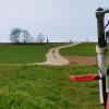 Soll zukünftig nicht nur mit dem Mountainbike befahrbar sein. Der neue Radweg ist so geplant, dass nur für ein kurzes Stück (hier im Vordergrund) unbefestigter Weg höhere Kosten durch Einbau eines entsprechenden Unterbaus anfallen würden. Die Zustimmung zu der gewählten Route könnte aber von der Überquerung der stillgelegten Bahntrasse abhängen. Dahinter ist schon der Frankenwinheimer Kirchturm zu sehen.
