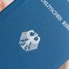 Ein Mann hält ein Heft mit dem Aufdruck "Deutsches Reich Reisepass" in der Hand (Symbolfoto).